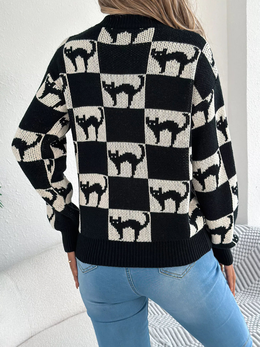 Back view of black and cream ghost checkerboard knit sweater with long sleeves