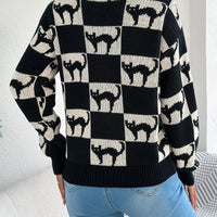 Back view of black and cream ghost checkerboard knit sweater with long sleeves