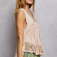 Pale pink lace-trim sleeveless peplum top with floral ruffled hem, side view