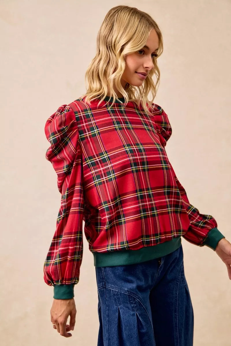 Red plaid top with exaggerated shoulders and puff sleeves, green ribbed hem detail