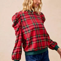 Red plaid top with exaggerated shoulders and puff sleeves, green ribbed hem detail