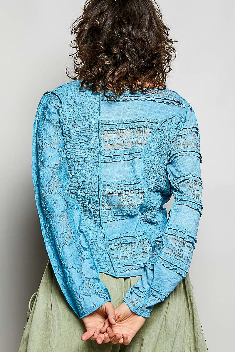 Teal blue lace long-sleeve top with exposed seams and round neckline, back view