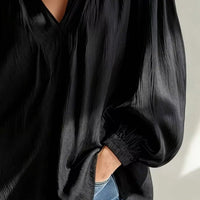 Black blouse with V-neck and long puff sleeves, elastic ruffled cuffs