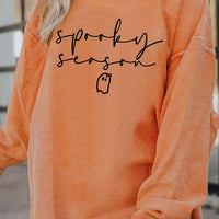 Orange ribbed pullover sweatshirt with “sprooky season” print and long sleeves