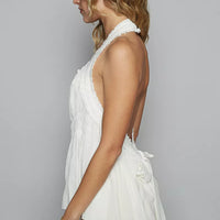 Off-white sleeveless halter top with smocked shirring and ruffle side trim
