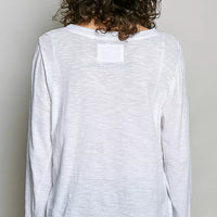 Off white long-sleeve knit top from back view with center yoke patch.