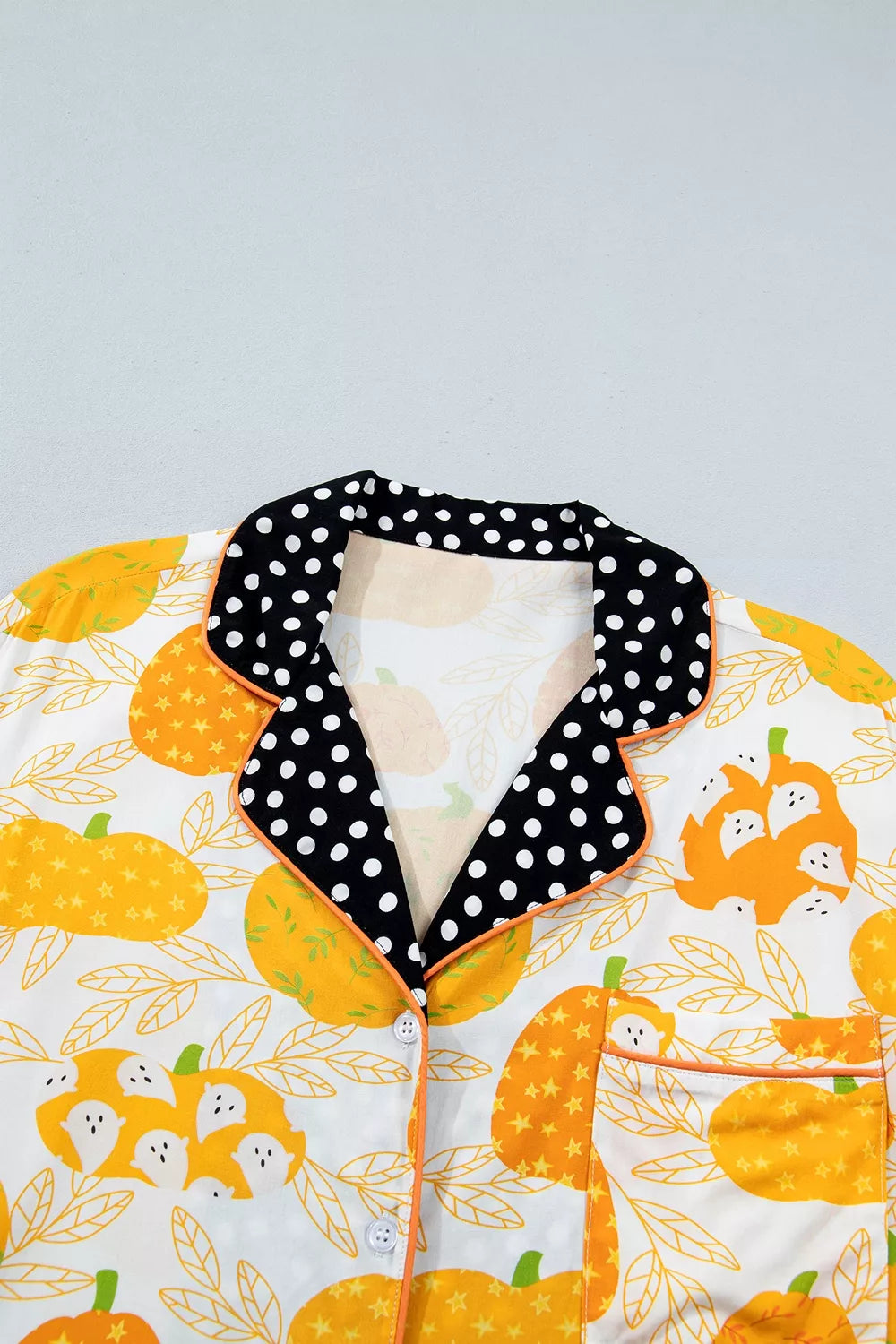 Close-up of pumpkin print pajama collar with black polka-dot trim