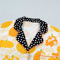 Close-up of pumpkin print pajama collar with black polka-dot trim