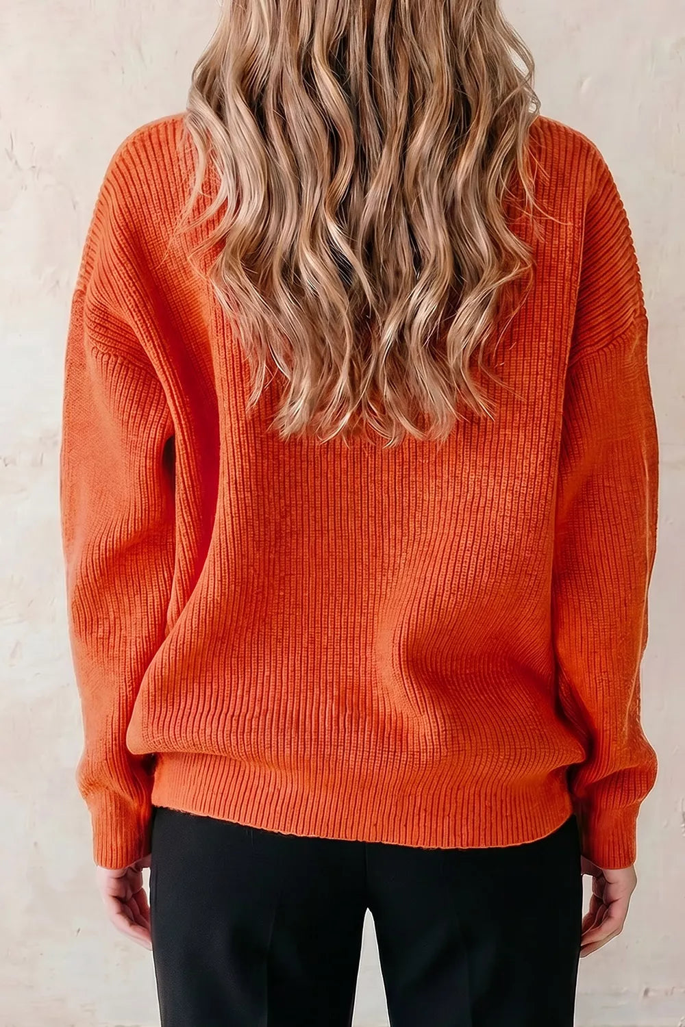 Orange knit sweater with long sleeves and crew neckline, back view
