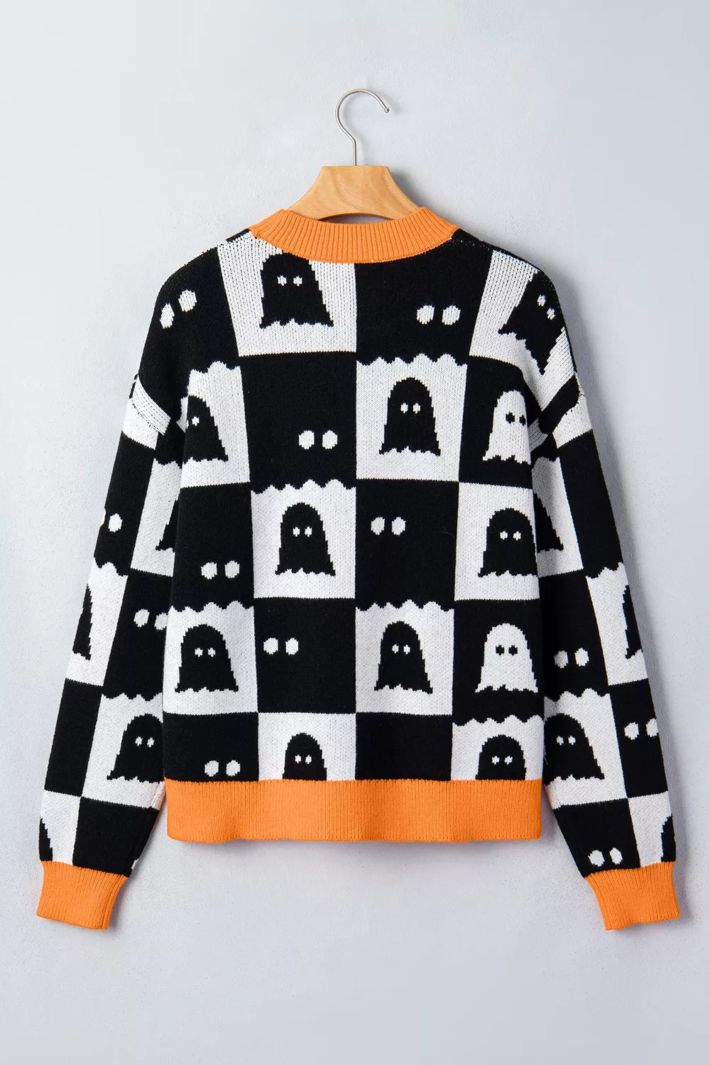 Back view of black and white ghost checkerboard sweater with orange ribbed trim