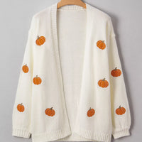 Off-white cardigan sweater on a hanger with scattered orange pumpkin embroidery.