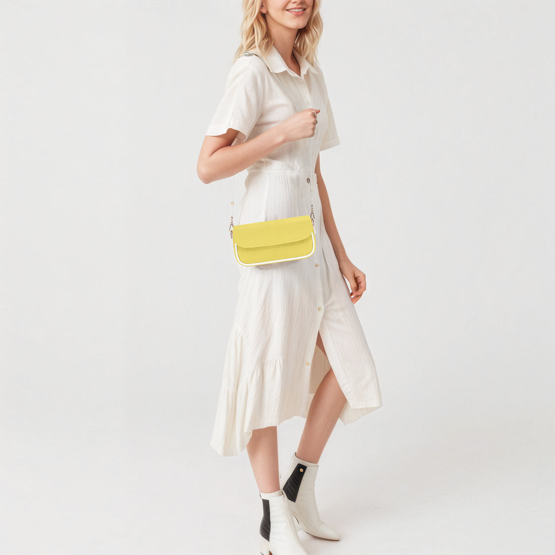 Yellow mini leather shoulder bag worn with front flap and gold chain strap.