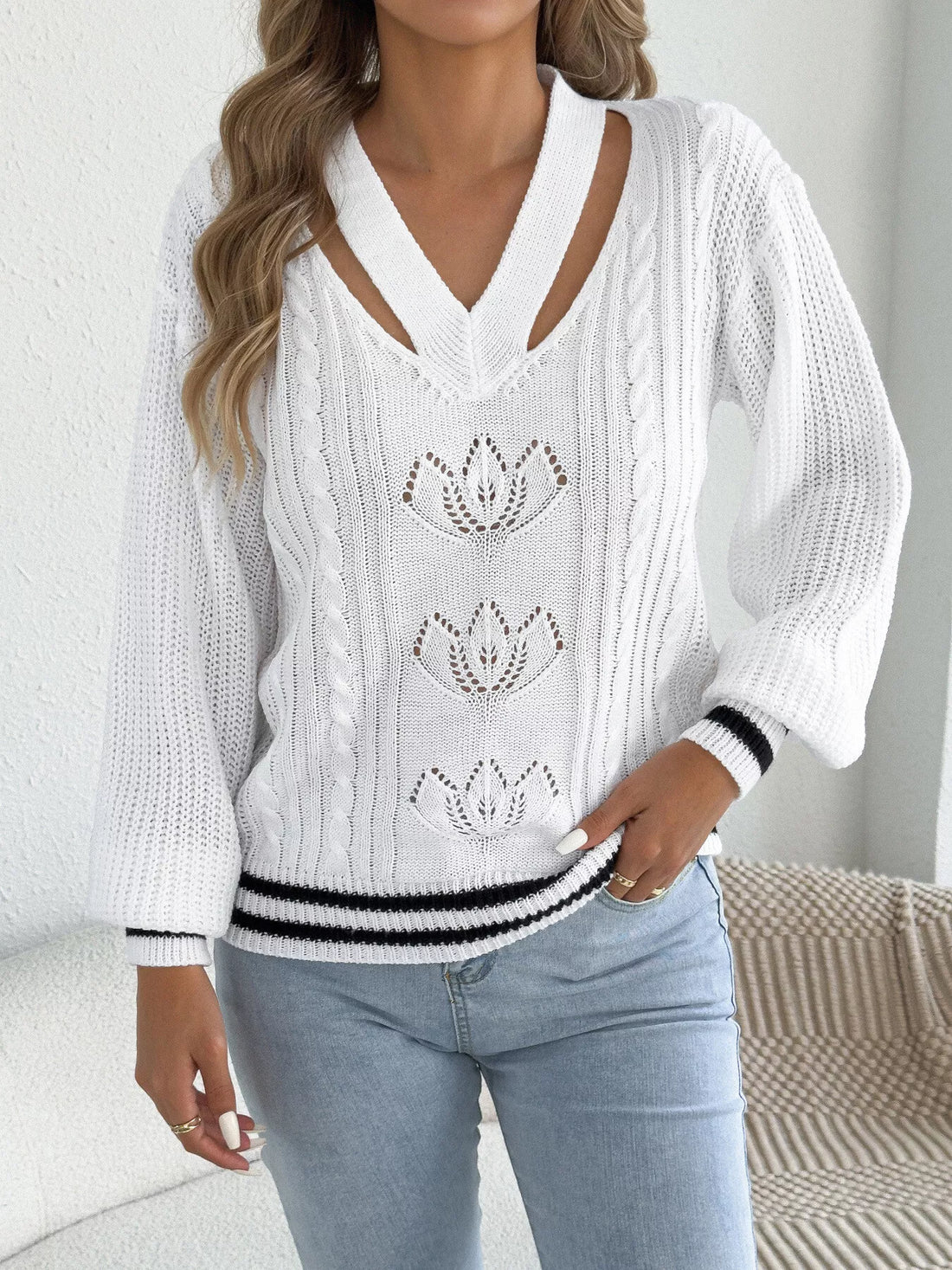 White cutout cable knit sweater with V-neck and decorative lotus-style knit motifs
