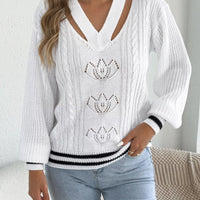 White cutout cable knit sweater with V-neck and decorative lotus-style knit motifs
