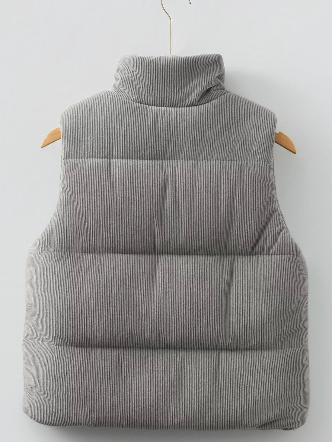 Gray corduroy puffer vest with stand collar; quilted, padded back panel with horizontal baffles.