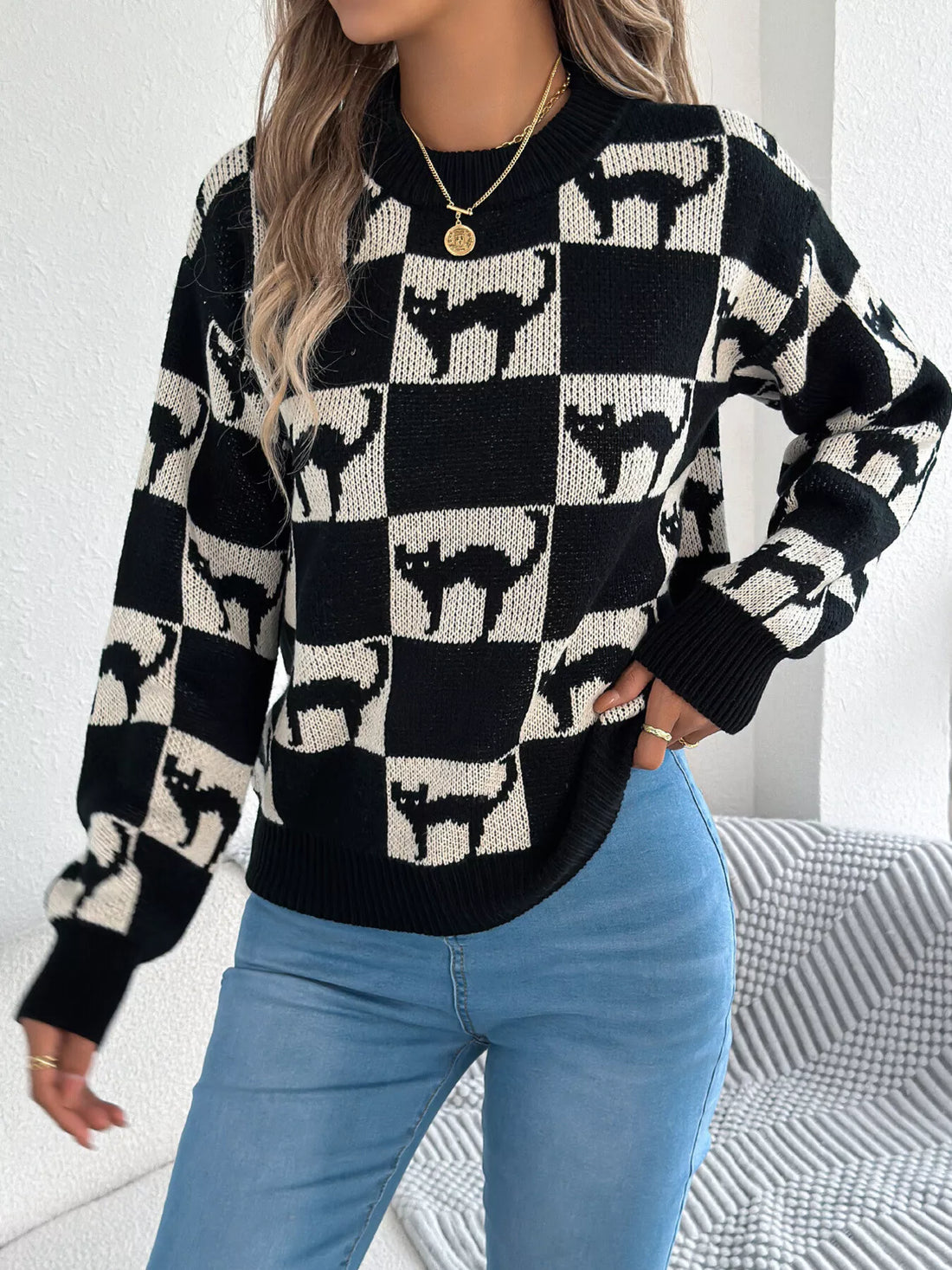 Black and cream ghost checkerboard knit sweater with crew neck and ribbed cuffs