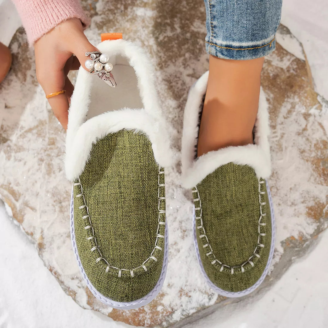 Green faux fur lined round toe slip-on shoes with white fur trim and stitched panels