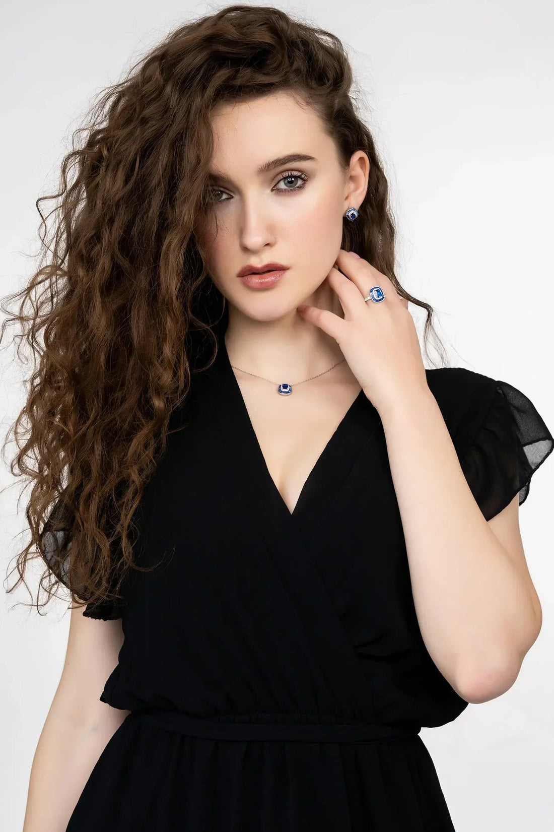 Sapphire pendant necklace with blue square pendant on silver chain at neckline