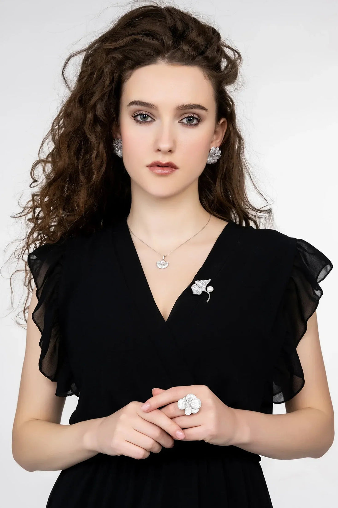 Silver flower stud earrings worn with black dress, five layered petals