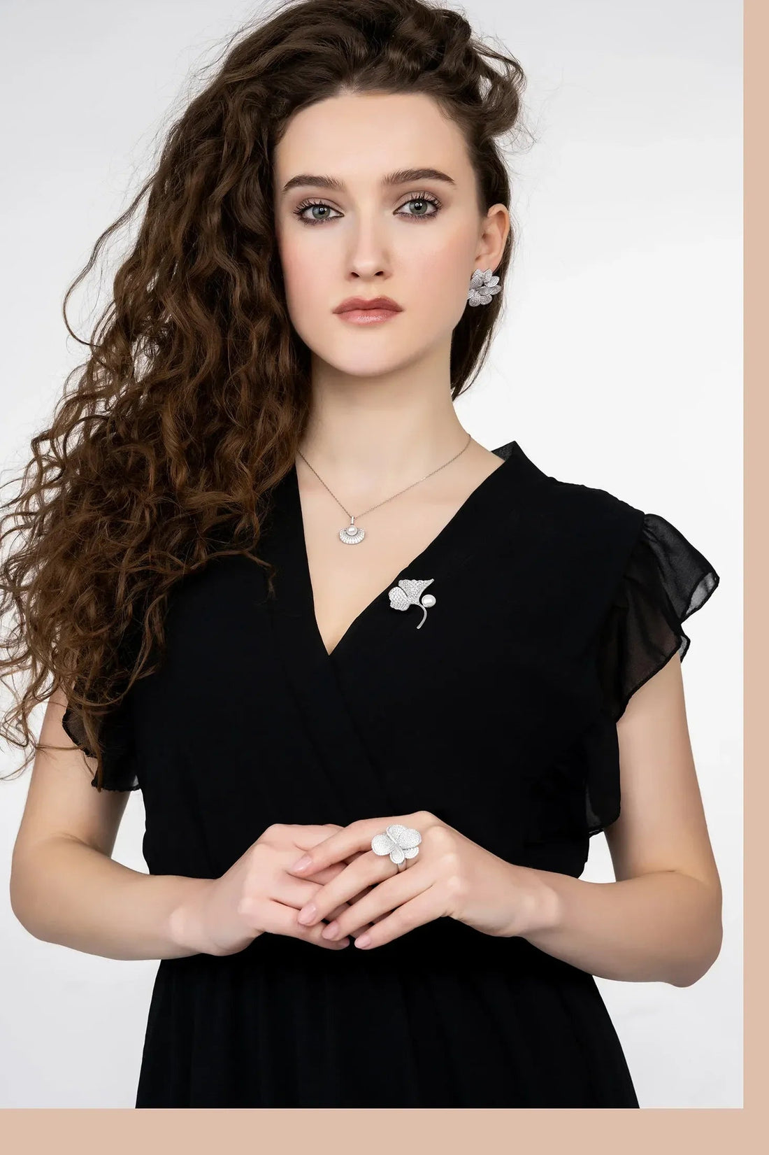 Silver flower stud earrings on model, five layered petals