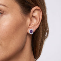Amethyst flower-shaped stud earrings with small crystal border, silver tone