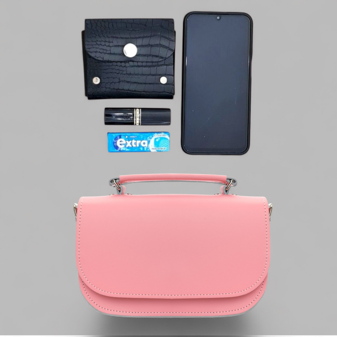 Pastel pink leather flap bag shown with phone and card for size