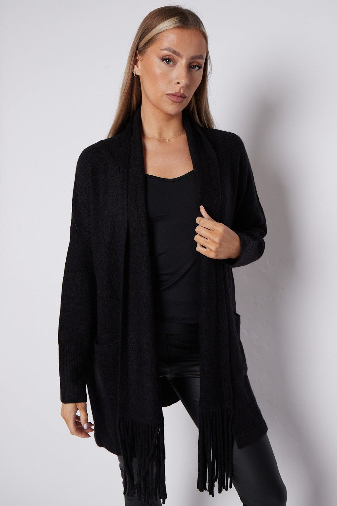 Black fringed cardigan with shawl collar and front pockets, draped open front