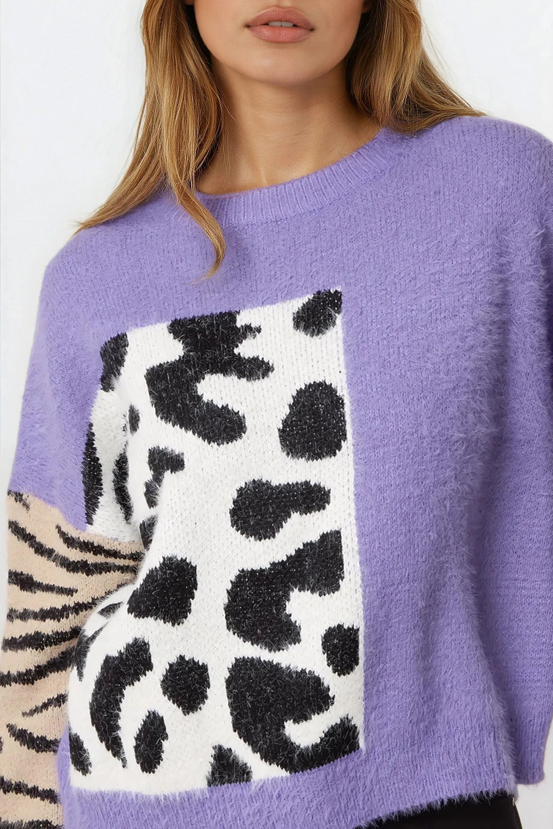 Purple knit jumper close-up: spotted square panel with zebra-striped sleeve cuff