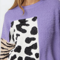 Purple knit jumper close-up: spotted square panel with zebra-striped sleeve cuff