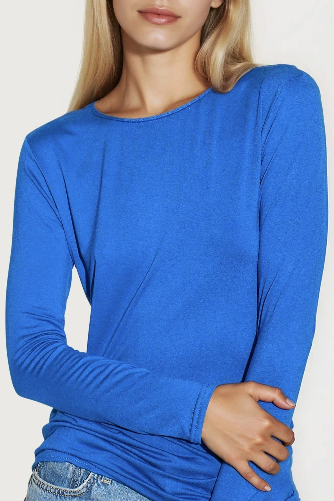 Royal blue round-neck long-sleeve top close-up on neckline and cuffs