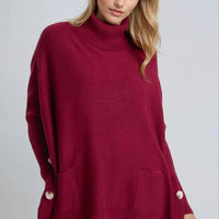 Burgundy roll-neck poncho jumper with side buttons and ribbed cuffs