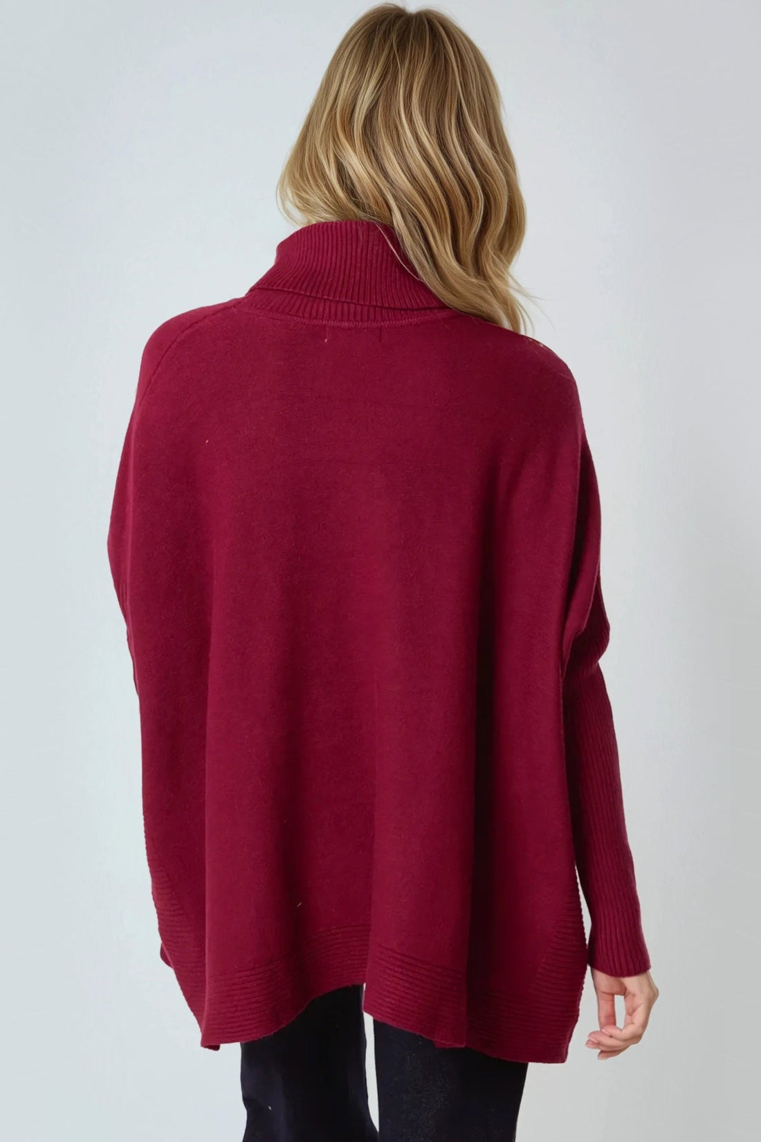 Burgundy roll-neck poncho jumper with ribbed collar in a relaxed back view