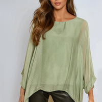 Light green silk blouse with batwing sleeves and round neckline