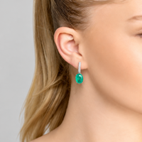 Silver drop earrings with emerald-green oval stone, worn on ear