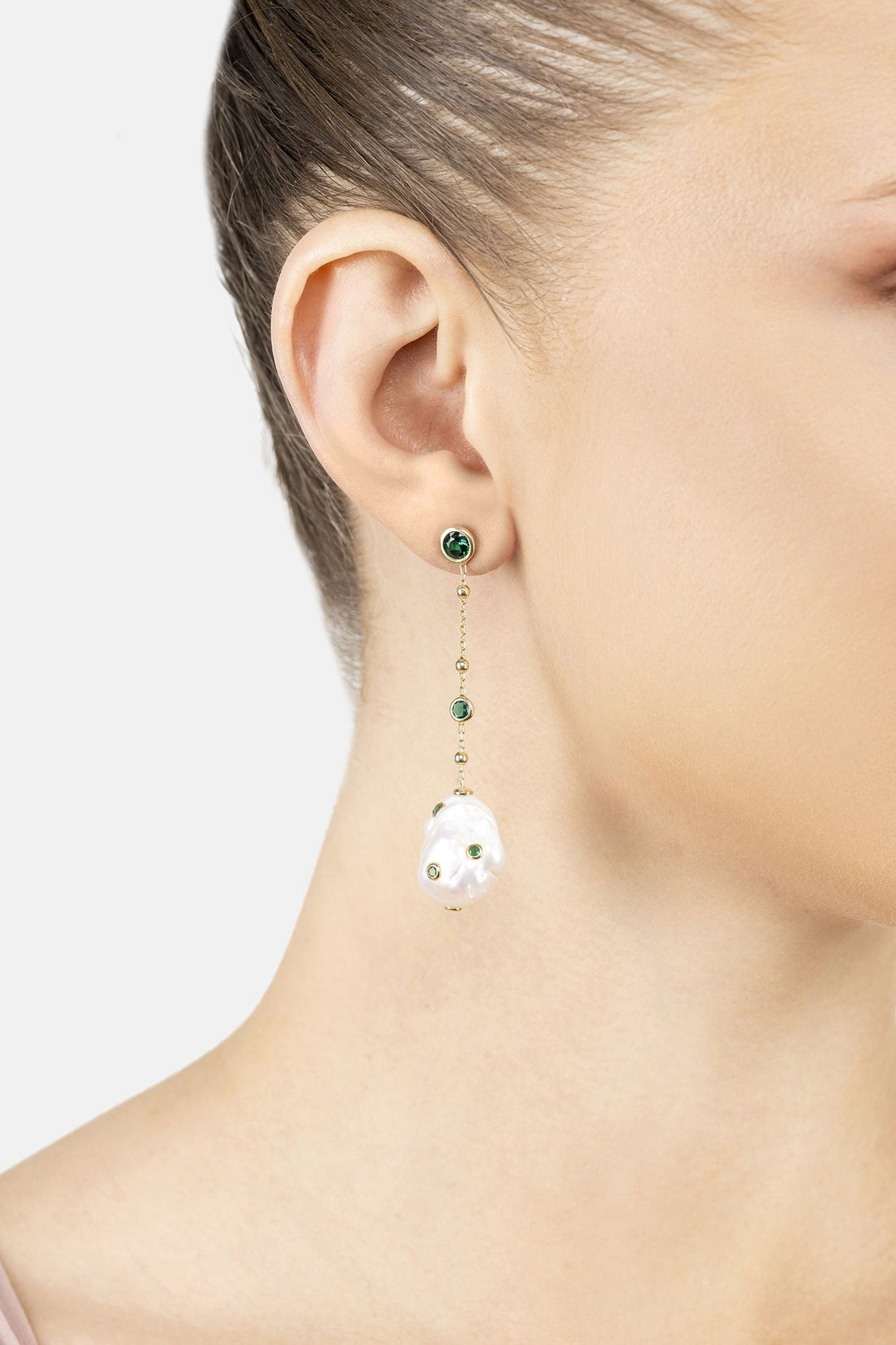 Gold drop earrings with white pearl teardrop dangle and emerald green stud details
