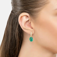 Emerald-green oval drop earring with small gold top detail on model ear
