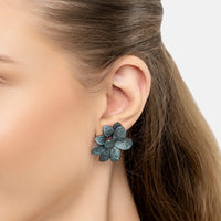 Close-up of large aqua flower stud earrings with sparkling textured petals
