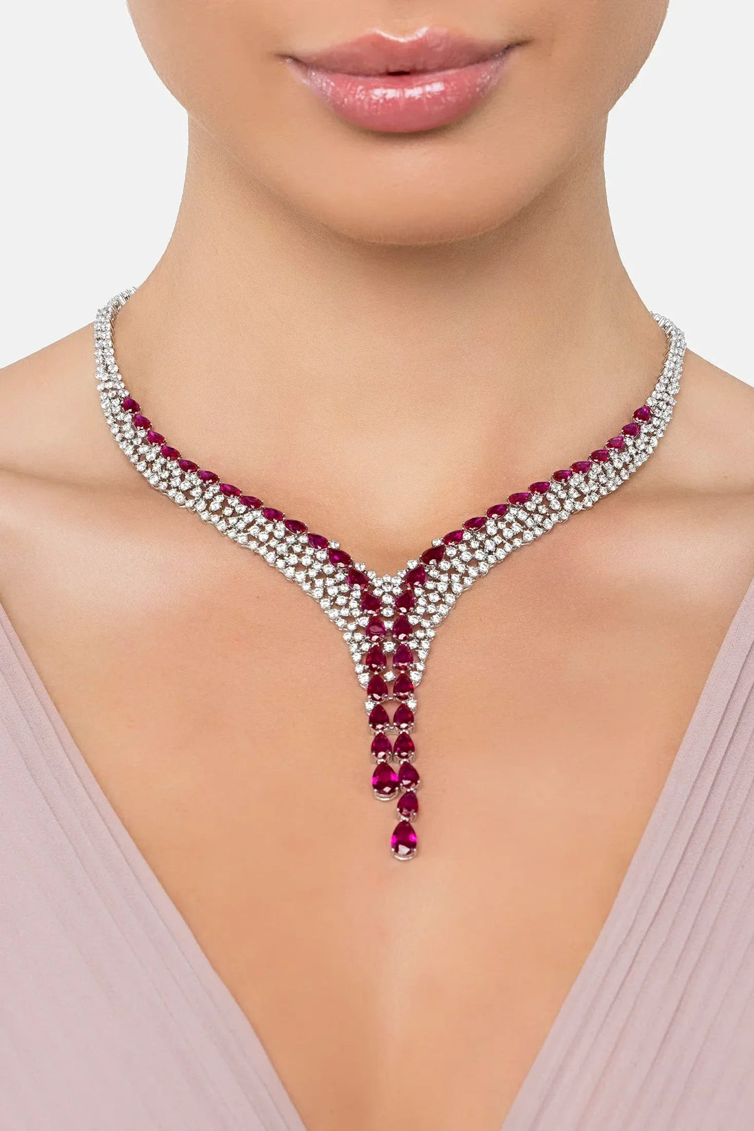 Silver statement necklace with ruby red faceted drops centered at the neckline
