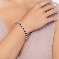 Sapphire tennis bracelet on wrist with oval blue stones and silver links