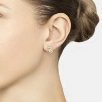 Small gold snake stud earring with green eye on side ear