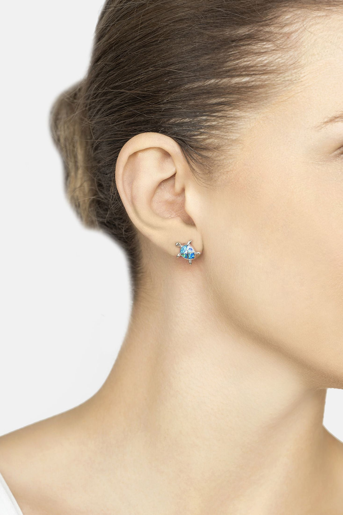 Blue opalite turtle stud earrings on ear with silver posts