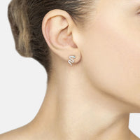 Silver snake stud earrings with small green CZ accent, worn on ear