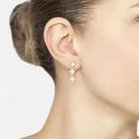 Small gold triple clover drop earrings with crystal sparkle on ear