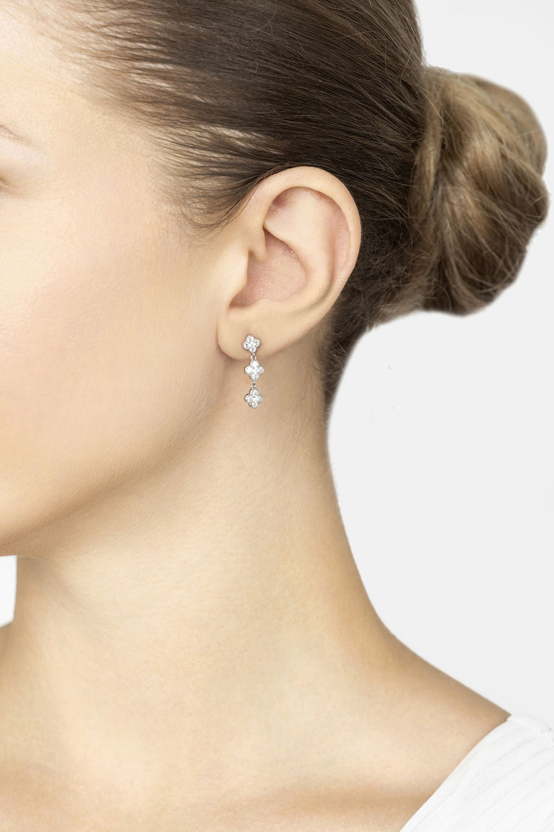 Silver mini triple clover drop earrings on model, three sparkling clover charms