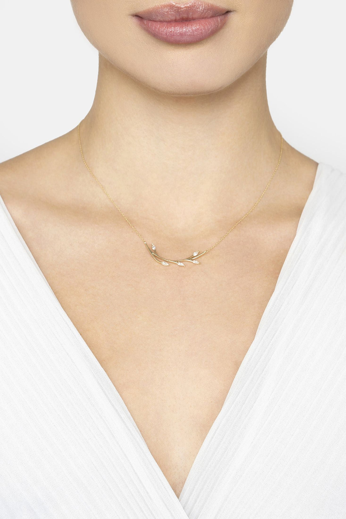 14k gold blooming branch necklace worn on collarbone, leaf-like pendant