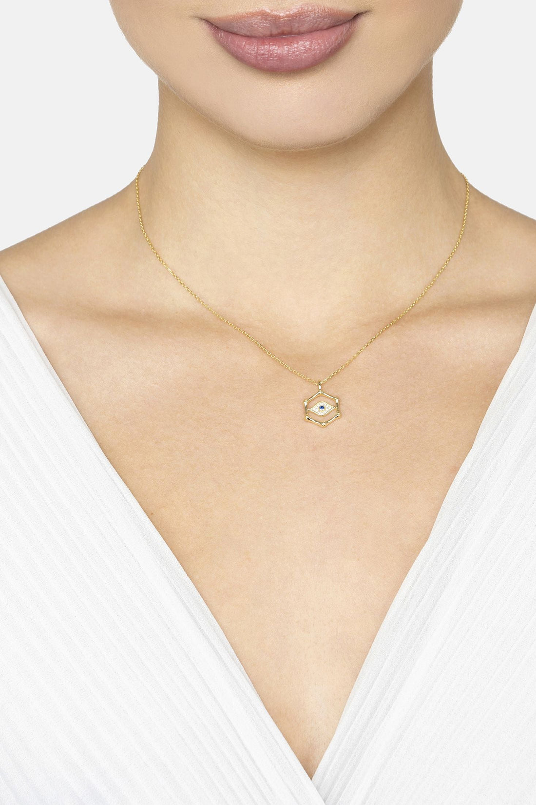 Gold chain necklace with small hexagon evil eye pendant on neckline