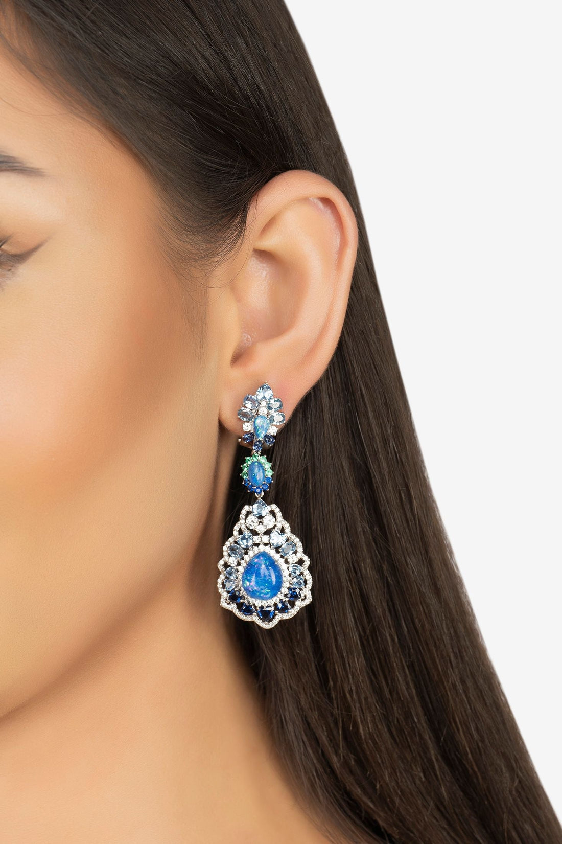 Blue opal drop earrings on model ear, silver-tone and blue teardrop stones