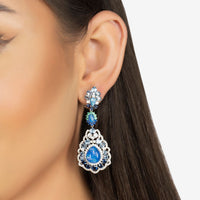 Blue opal drop earrings on model ear, silver-tone and blue teardrop stones