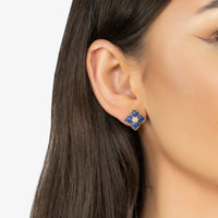 Gold-tone blue clover flower stud earrings on ear