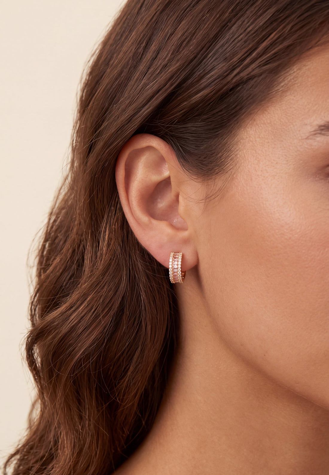 Gold huggie hoop earrings with pink baguette morganite stones and sparkle accents